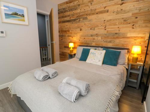 a bedroom with a large bed with towels on it at Y Bwthyn in Llanbedr