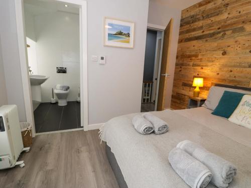 a bedroom with a bed with towels on it at Y Bwthyn in Llanbedr