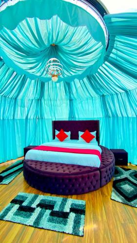 a bedroom with a bed in a blue room at The Mountain Vault in Barog