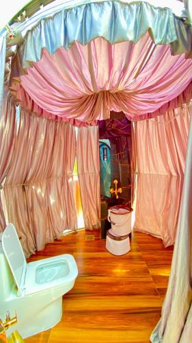 a bathroom with a tent with a toilet and a sink at The Mountain Vault in Barog