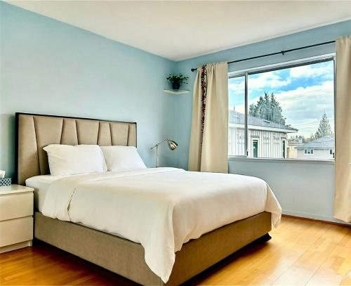 a bedroom with a large bed and a large window at Private Ensuite Room Near YVR Airport Vancouver West in Vancouver