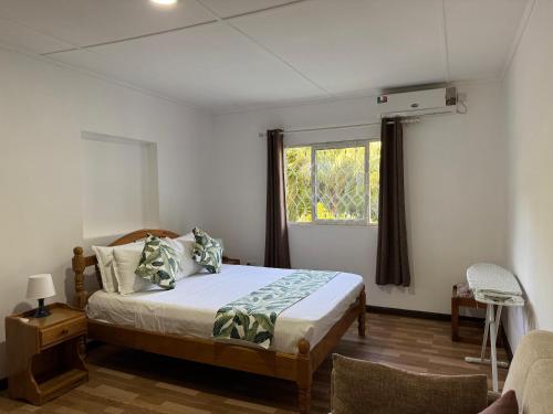a bedroom with a bed and a window at Paul's Residence in Mahe