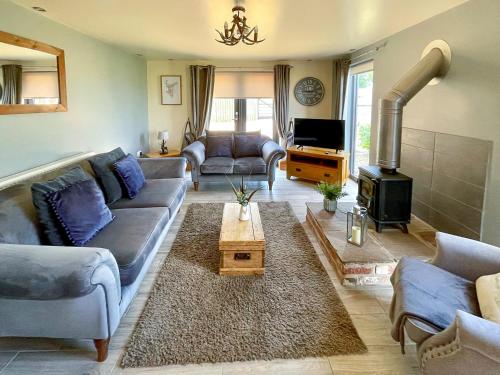 a living room with a couch and a fireplace at Redroofs Barn - 28184 in Weston