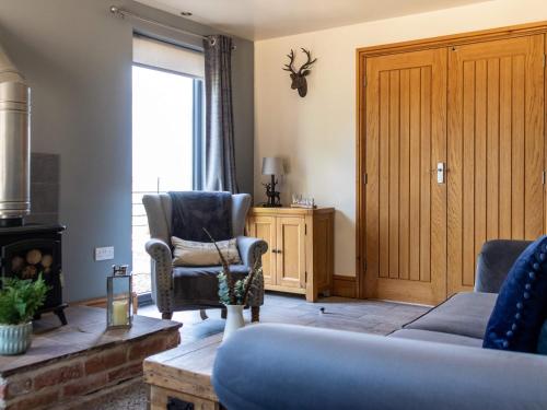 a living room with a couch and a chair at Redroofs Barn - 28184 in Weston