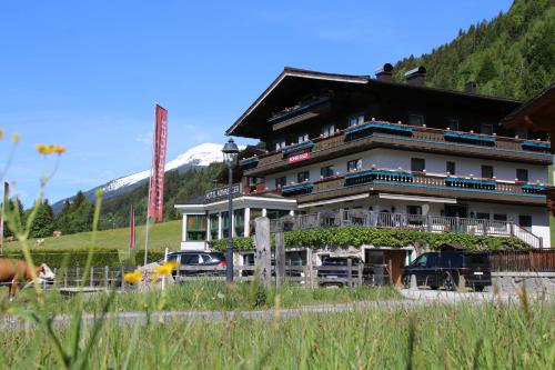 a large building with cars parked in front of it at Landhaus Rohregger in Neukirchen am Großvenediger