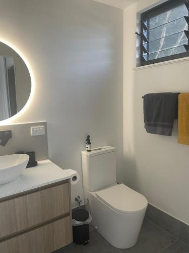 a bathroom with a white toilet and a sink at Eden on Beach in Palm Cove