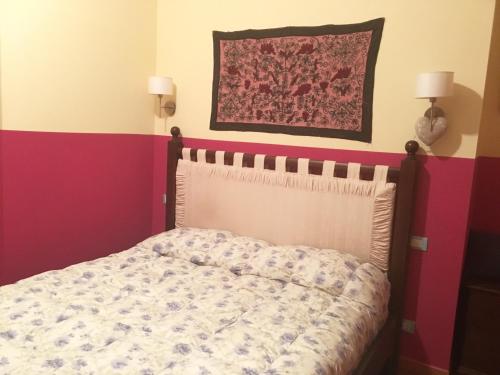 a bed in a room with red and pink stripes at Mondello Room in Mondello