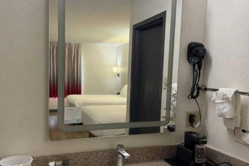 a mirror in a hotel room with a bedroom at Ramada by Wyndham Harrisonburg in Harrisonburg