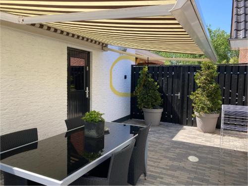 a patio with a table and chairs under an umbrella at Holiday Tiny House in Spakenburg Bed & Bike in Spakenburg