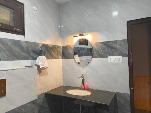 a bathroom with a sink and a mirror at Pratham Place in Kasol