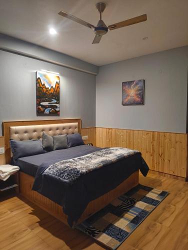 a bedroom with a bed and a ceiling fan at Pratham Place in Kasol