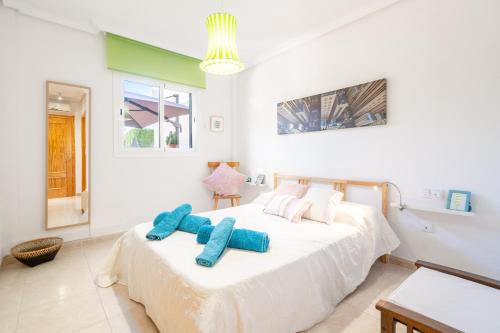 a bedroom with a bed with two blue pillows on it at Can Tomeu in Calas de Mallorca