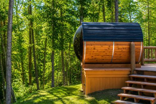 a tree house with a staircase in the woods at Fiddler Lake Resort - Deer 79 in Mille-Isles