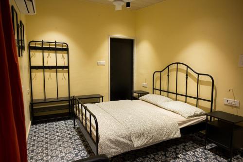 a bedroom with a bed and two tables and a door at Valhalla Villa in Panvel