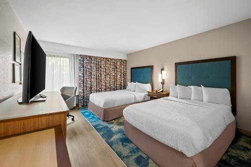 a hotel room with two beds and a flat screen tv at Hampton Inn Naples - I-75 in Naples