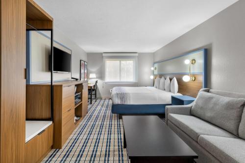 a hotel room with a bed and a couch at AmericInn by Wyndham Delafield-Milwaukee in Delafield