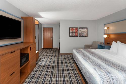 a hotel room with a bed and a flat screen tv at AmericInn by Wyndham Appleton North Little Chute in Appleton