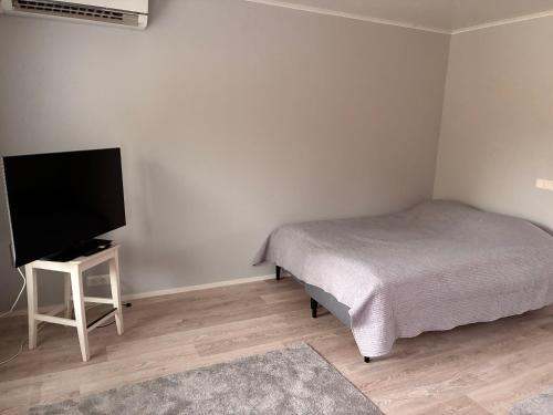 a bedroom with a bed and a flat screen tv at Koivukuja in Köyliö