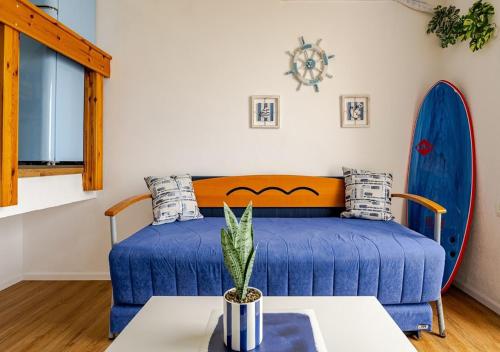 a bedroom with a blue bed and a table at Nahariya SEA VIEW, Ha-aliya in Nahariyya