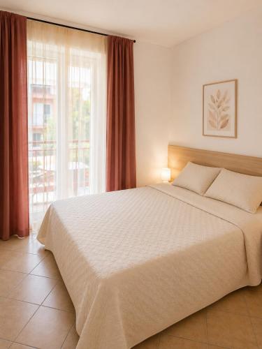a bedroom with a large bed and a large window at Residence Roberta con piscina - Agenzia Cocal in Caorle