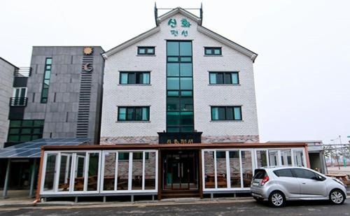 a building with a car parked in front of it at Daecheon sinhwa pension in Boryeong