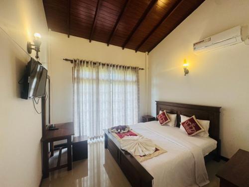 a bedroom with a bed and a television in it at Titanic Villa Kandy in Kandy