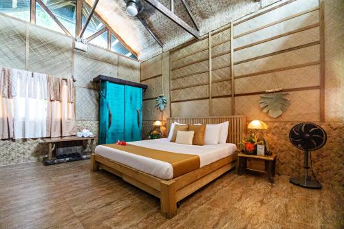 a bedroom with a large bed and a fireplace at Nature's Eye Resort in Guimaras