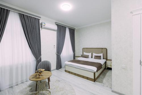 a hotel room with a bed and a table at Bog’ishamol Hotel Urgut in Min-Bulak