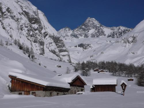 a snow covered mountain with a cabin in the foreground at Wurlerhof in Kals am Großglockner