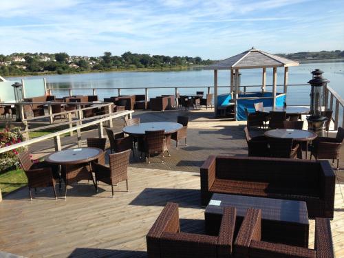 a deck with tables and chairs and a view of the water at The Old Quay House in Hayle