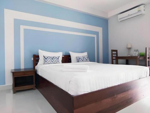 a bedroom with a large bed with a blue wall at Iyara Residence in Trat