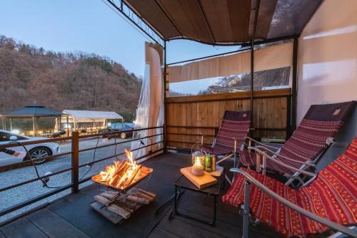 a balcony with two chairs and a fire pit on a boat at Jade Byeolbit Caravan in Chuncheon