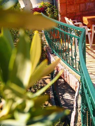 a green bench sitting next to a building at Zoro Apartments in Sveti Stefan