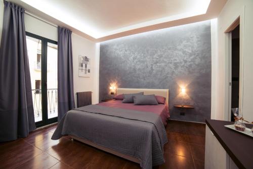 1 dormitorio con 1 cama y una gran pintura en la pared en Glam House, en Salerno