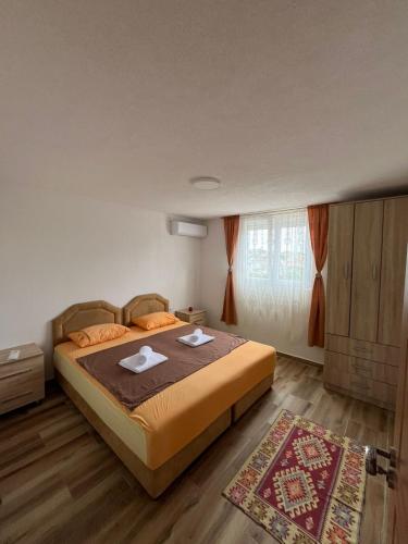 a bedroom with a bed with two towels on it at Apartmani MINA in Bar