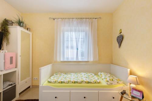 a small bedroom with a bed and a window at Villa am Keltenberg - La Stella in Glauburg