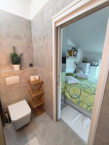 a bathroom with a toilet and a bed in a room at Apartments and rooms Roberto B. in Valun