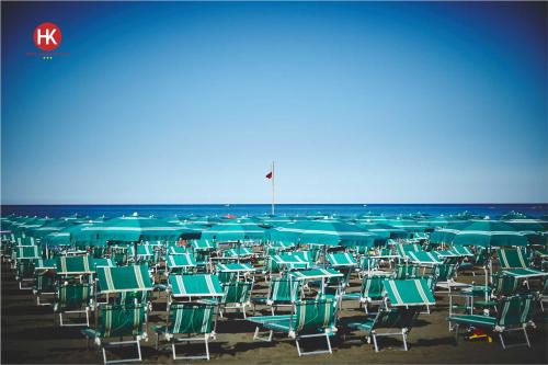 a bunch of chairs and umbrellas on a beach at Hotel Residence Key Club in Montalto di Castro