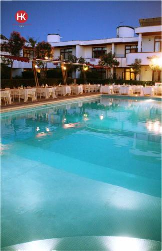 a large swimming pool in front of a hotel at Hotel Residence Key Club in Montalto di Castro