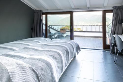 a bedroom with a large bed and a balcony at Lake View Apartments in Acquaseria
