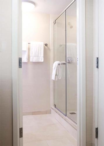 a white bathroom with a glass shower with towels at Hilton Orlando Buena Vista Palace - Disney Springs Area in Orlando
