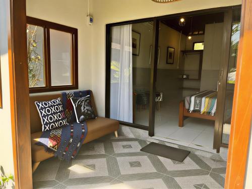 a living room with a couch and a sliding glass door at Secret Garden Surf Resort, walk to waves in Pulau Gilkaliantan