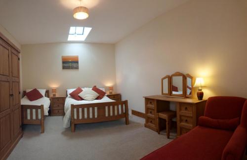 a bedroom with two beds and a desk with a mirror at Rhyd y Gorlan in Cemmaes