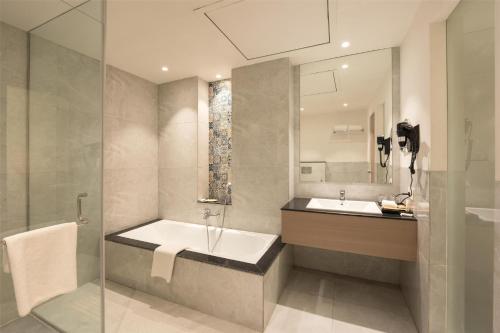 a bathroom with a tub and a sink and a mirror at Best Western Plus Phagwara in Phagwāra