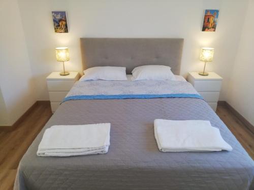 a bedroom with a bed with white towels on it at Atalaia Garden House in Giz