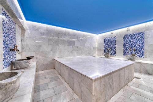 un ampio bagno con vasca e soffitto blu di Kleopatra Melissa Hotel a Alanya