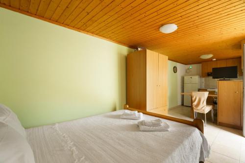 a bedroom with a bed with two towels on it at Studio Liana in Frikes