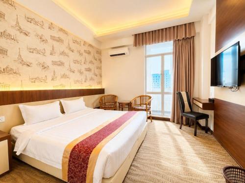a hotel room with a bed and a television at THE REED HOTEL Melaka in Malacca