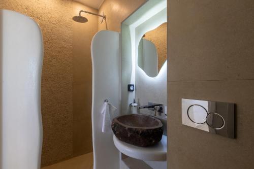 a bathroom with a sink with a wooden bowl at Villa Karras - Sea & Mountain View in Perissa