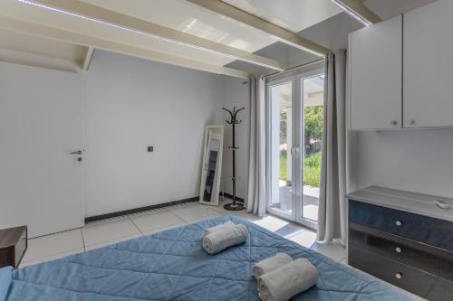 a bedroom with a blue bed with two pillows on it at Mario's Kassiopi in Kassiopi